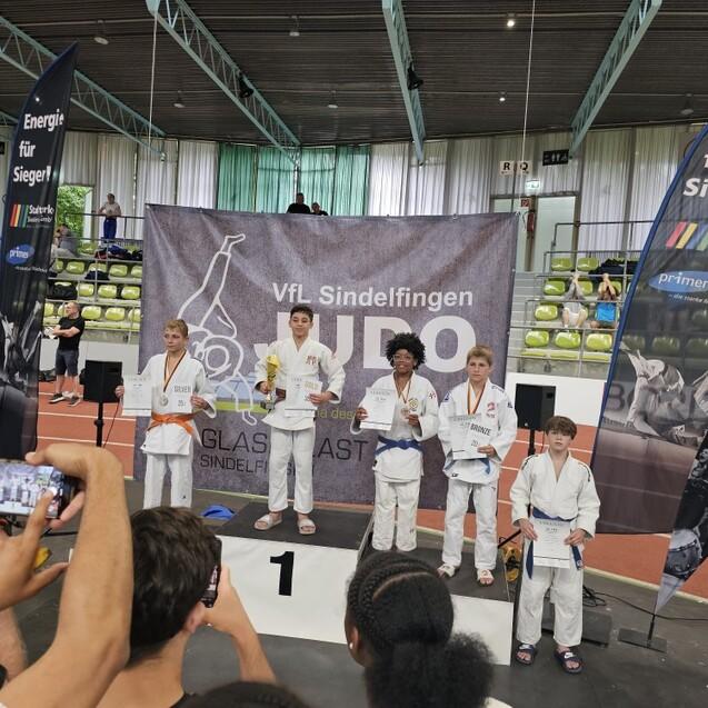 Junge Judo-K&auml;mpfer stehen auf dem Podium mit Medaillen und Urkunden, vor einer B&uuml;hne beim VfL Sindelfingen.