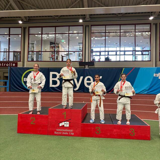 Vier Judoka stehen auf dem Podium des Bayer Judo Cups und halten ihre Medaillen in der Hand.