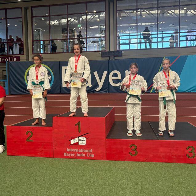 Vier junge Judoka stehen auf dem Siegerpodest beim Internationalen Bayer Judo Cup, Medaillen um den Hals.