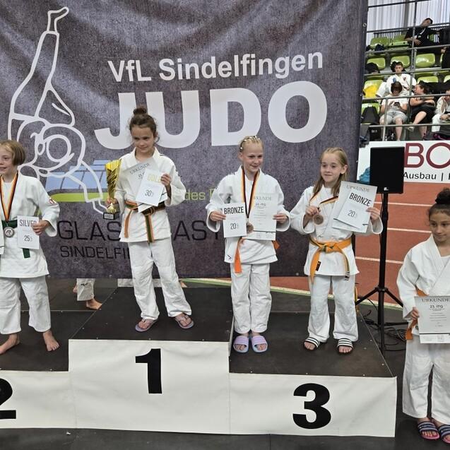 F&uuml;nf Kinder in Judokleidung stehen auf einem Podest und halten Medaillen und Urkunden beim VfL Sindelfingen.