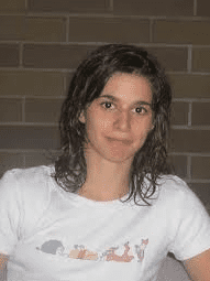 Portr&auml;t einer Person mit nassen, lockigen Haaren, die ein wei&szlig;es T-Shirt mit farbenfrohem Tiermotiv tr&auml;gt.