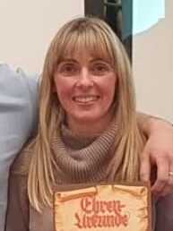 Gruppe von f&uuml;nf Personen h&auml;lt Urkunden und l&auml;chelt vor einem Projektorbildschirm mit der Aufschrift &bdquo;Ehrung f&uuml;r das Vereinsmitglieder&ldquo;.